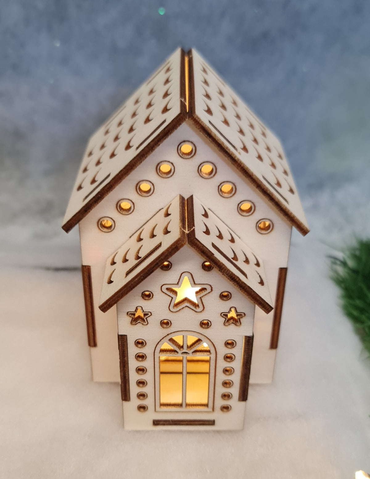 A quaint small house topped with a shining star, set against a clear sky, exuding charm and warmth.