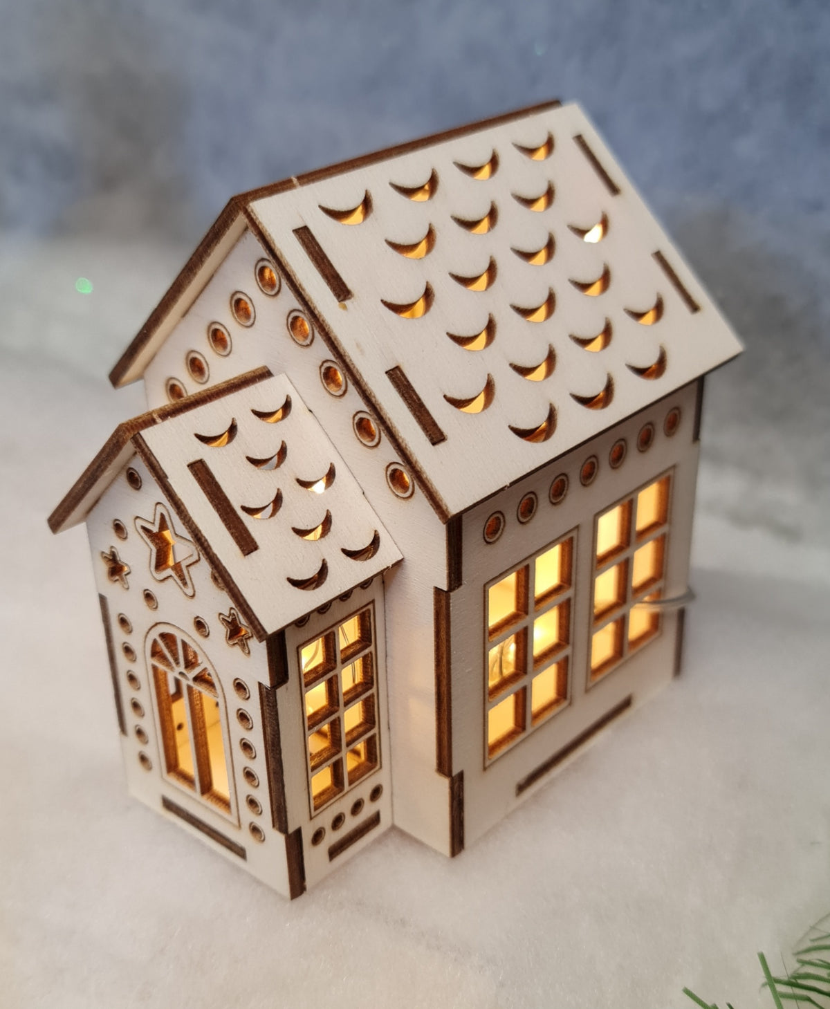 A quaint small house topped with a shining star, set against a clear sky, exuding charm and warmth.